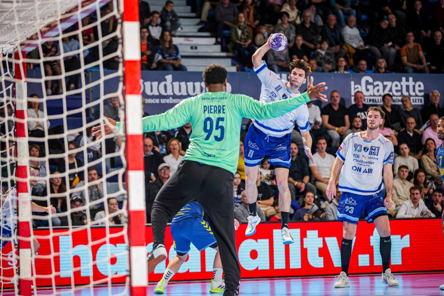 Joueur de handball lançant le ballon vers le but.