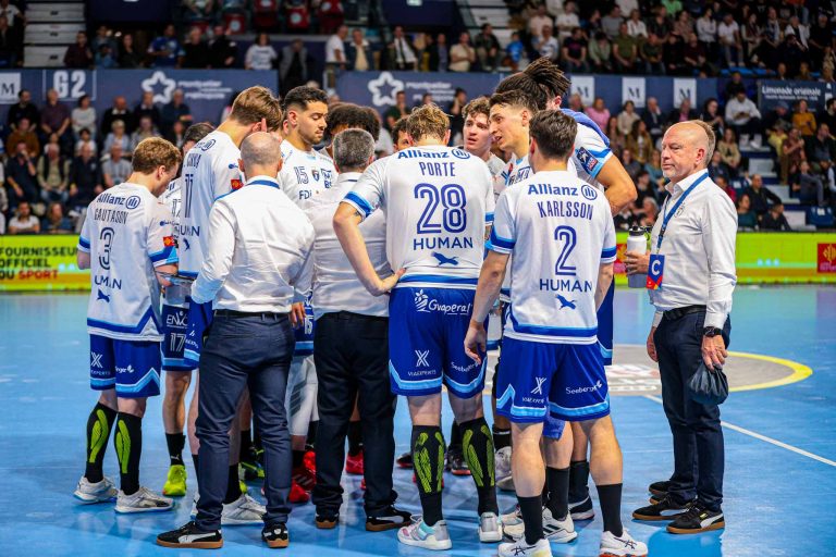 Équipe de handball en discussion stratégique sur le terrain.