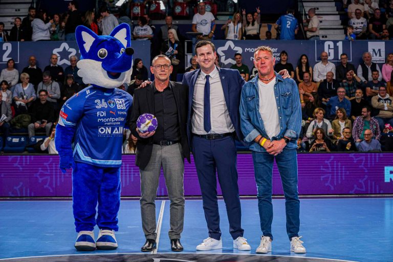 Personnes posant avec mascotte bleue à l'événement sportif.