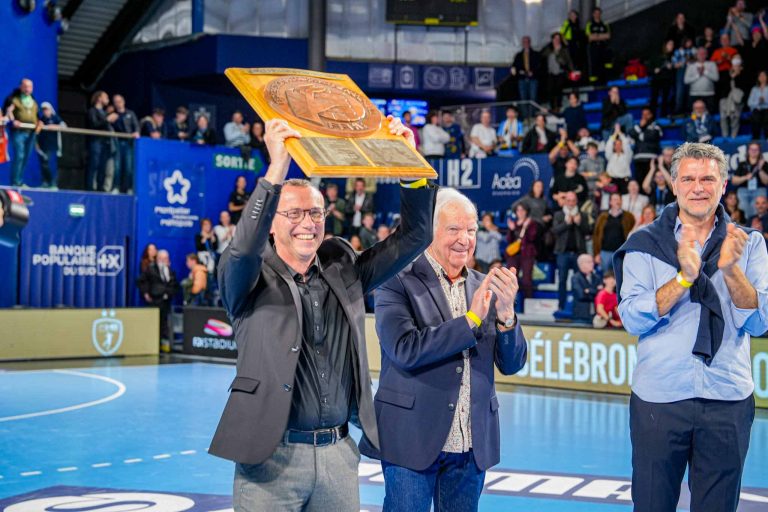 Célébration avec trophée et applaudissements dans une salle.