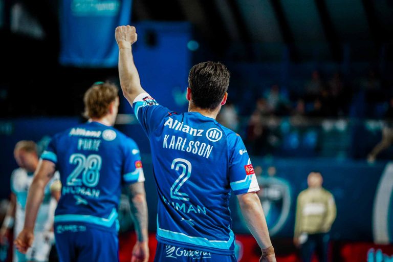Joueur de handball levant le poing, match en cours.