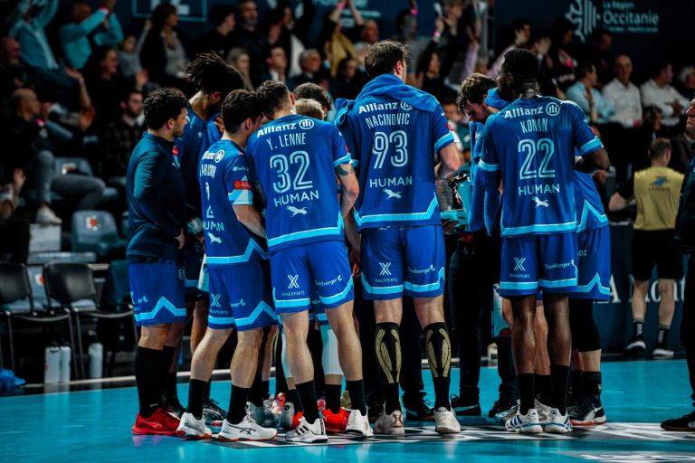 Équipe de handball en discussion sur le terrain.
