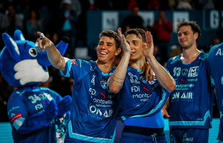 Joueurs de handball célèbrent avec la mascotte.