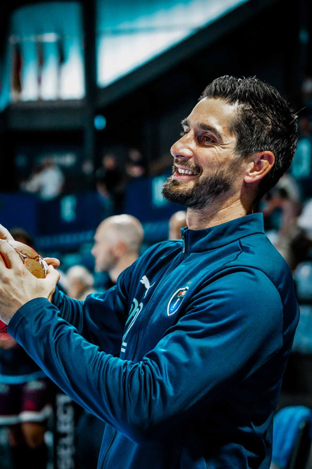 Joueur de handball souriant tenant le ballon.
