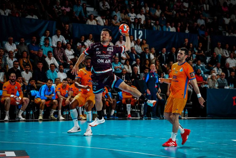 Joueur de handball en plein saut, match compétitif.