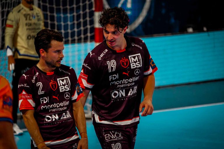 Joueurs de handball discutant sur le terrain.