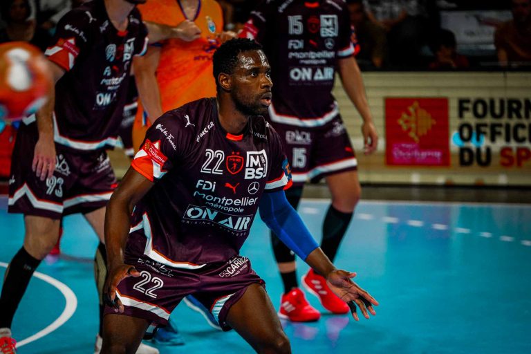 Joueur de handball en pleine action sur le terrain.