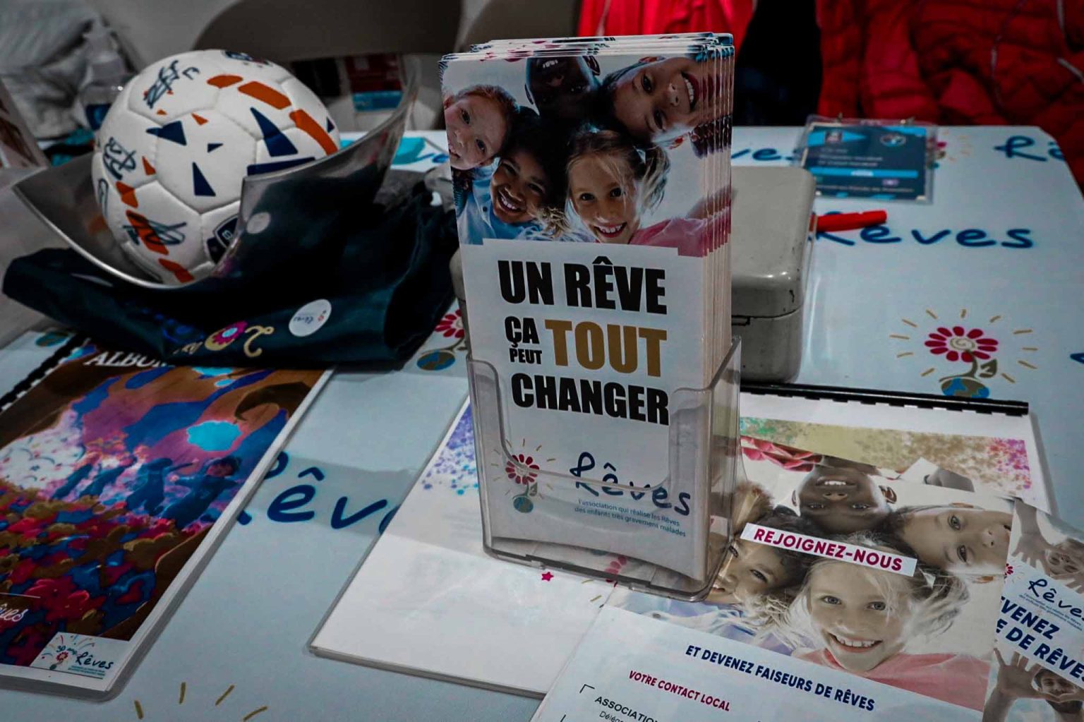 Stand d'association caritative avec brochures et ballon.