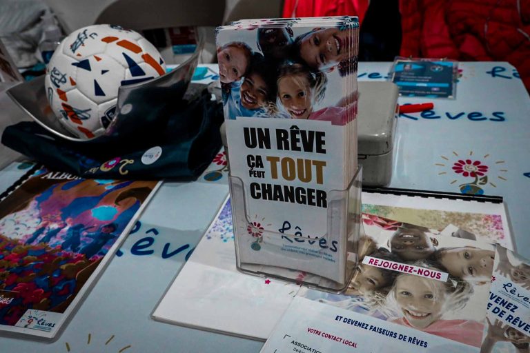 Stand d'association caritative avec brochures et ballon.