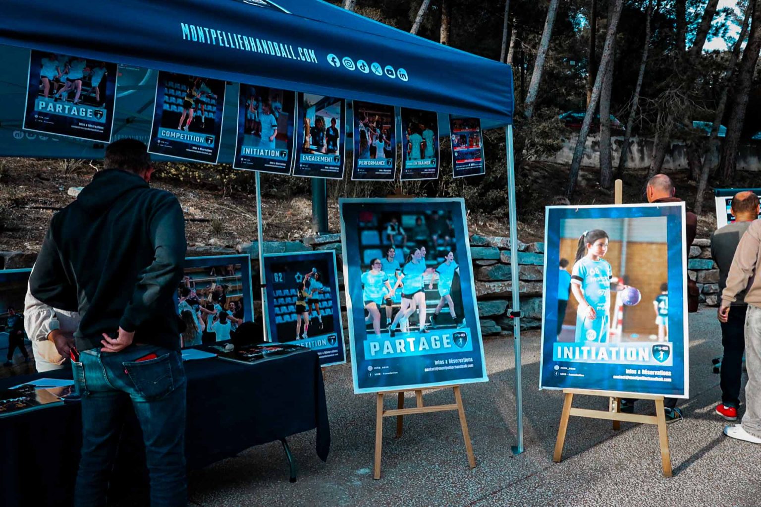 Stand Montpellier Handball avec affiches et visiteurs.