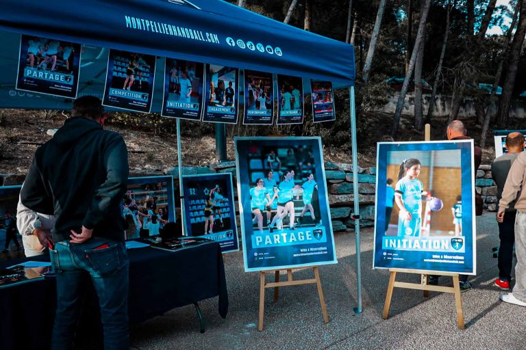 Stand Montpellier Handball avec affiches et visiteurs.