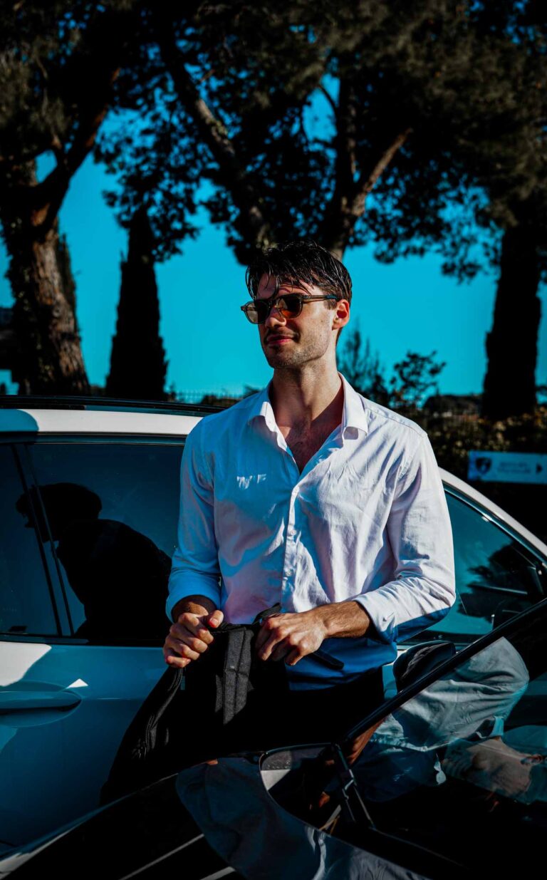 Homme en chemise blanche avec voiture dans la nature.