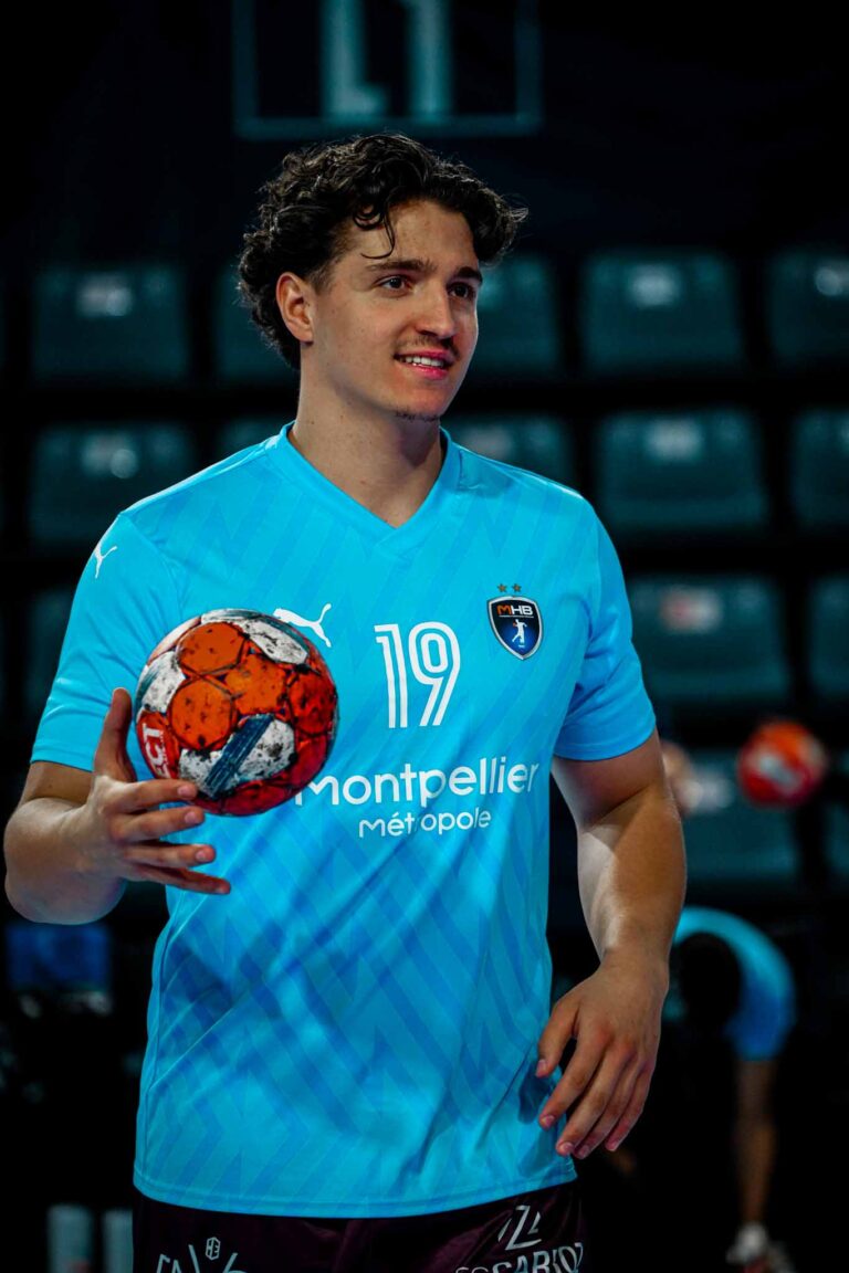 Joueur de handball avec ballon, maillot bleu.