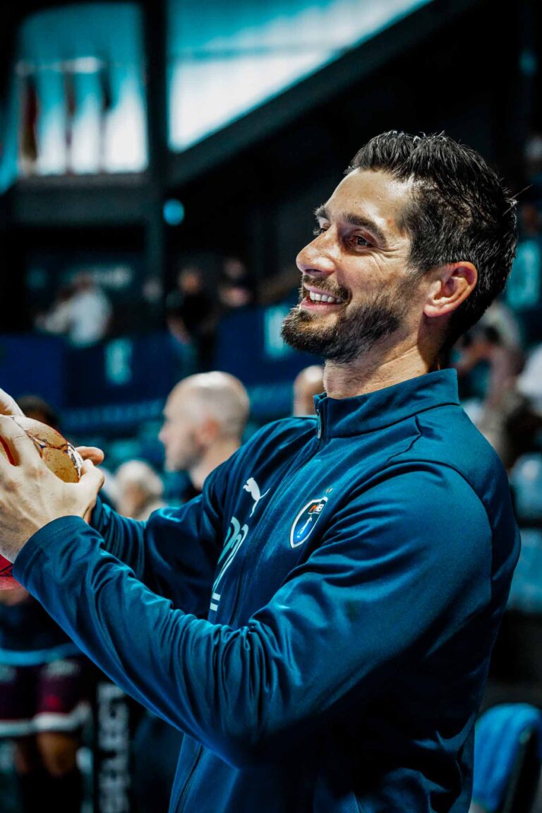 Joueur de handball souriant avec ballon.