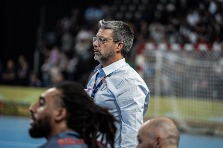 Entraîneur d'équipe de handball observant le match.