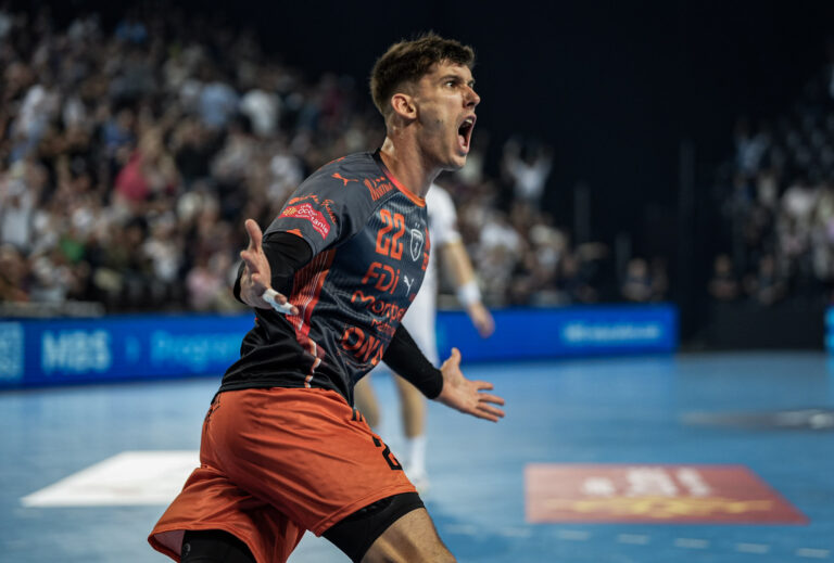 Joueur de handball célébrant un but réussi.