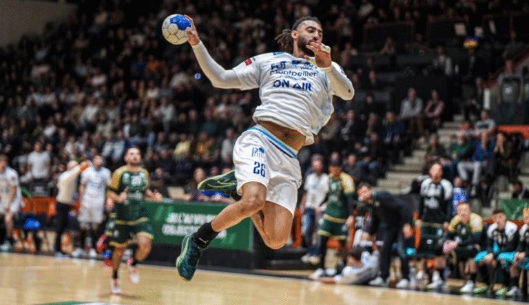 Joueur de handball en plein saut, match en cours.