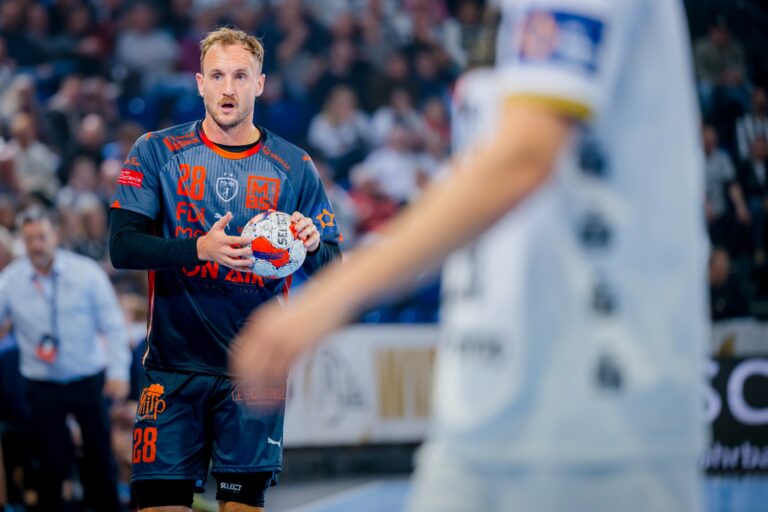 Joueur de handball tenant le ballon en match.