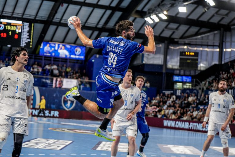 Match de handball en salle avec joueurs en action.