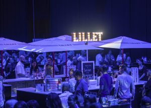 Bar Lillet animé avec des parasols en soirée.