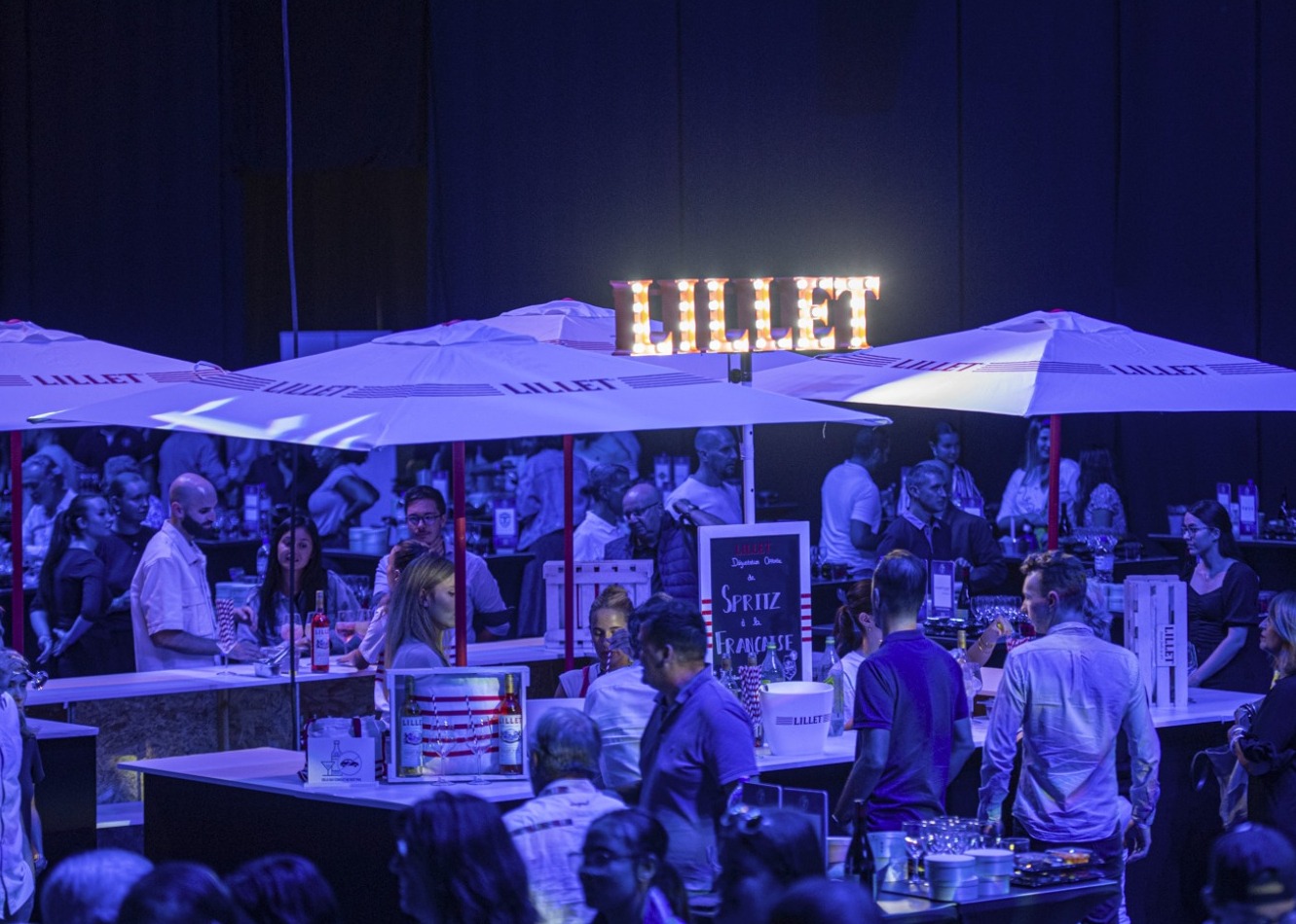 Bar Lillet animé avec des parasols en soirée.
