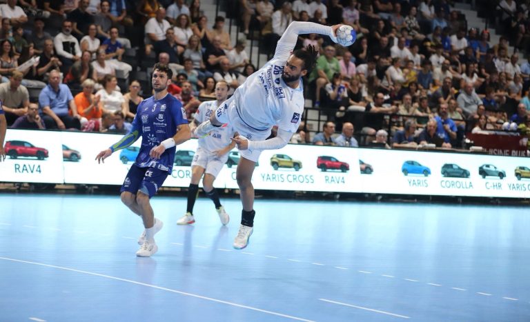 Joueur de handball en plein saut dans un match.