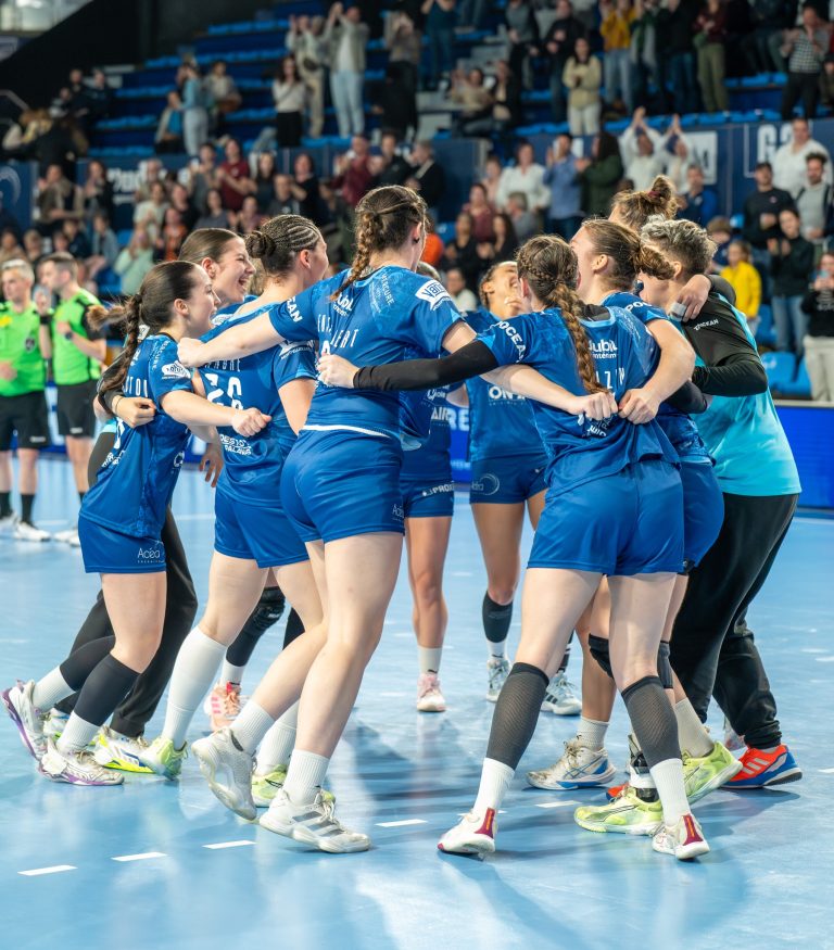Équipe de handball féminin célébrant une victoire.