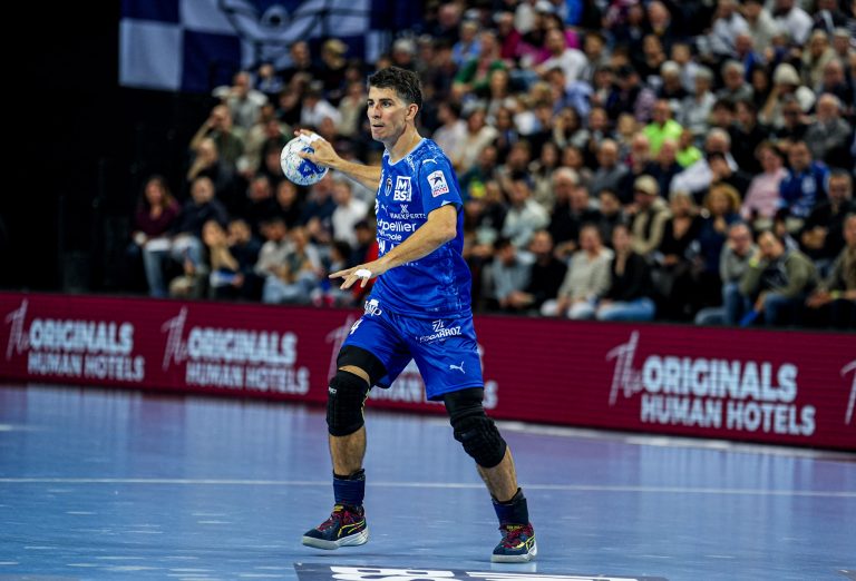 Joueur de handball pendant un match, tenue bleue.