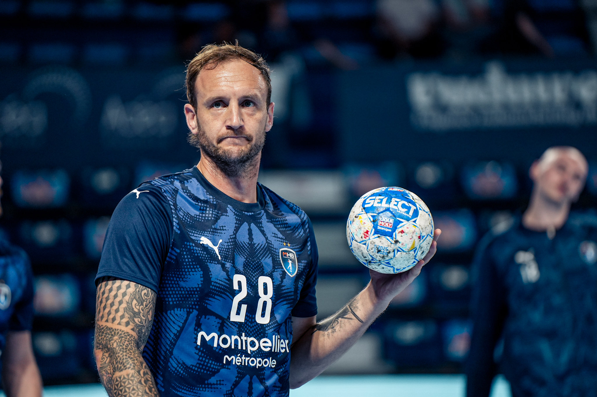 Joueur de handball tenant un ballon sur le terrain.