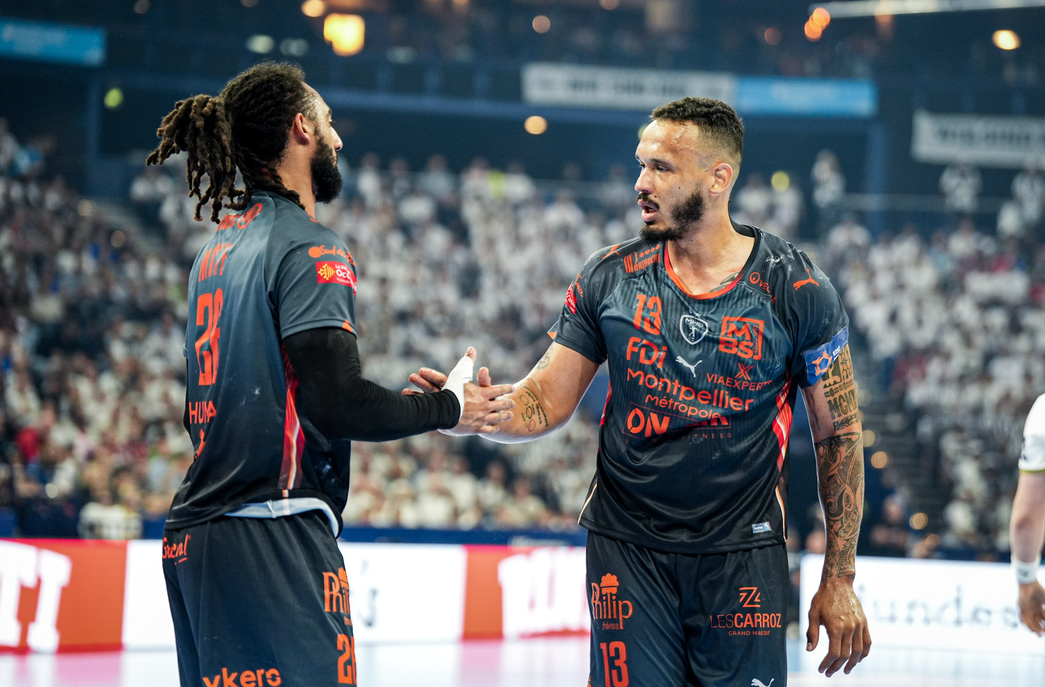 Joueurs de handball se saluant sur le terrain.