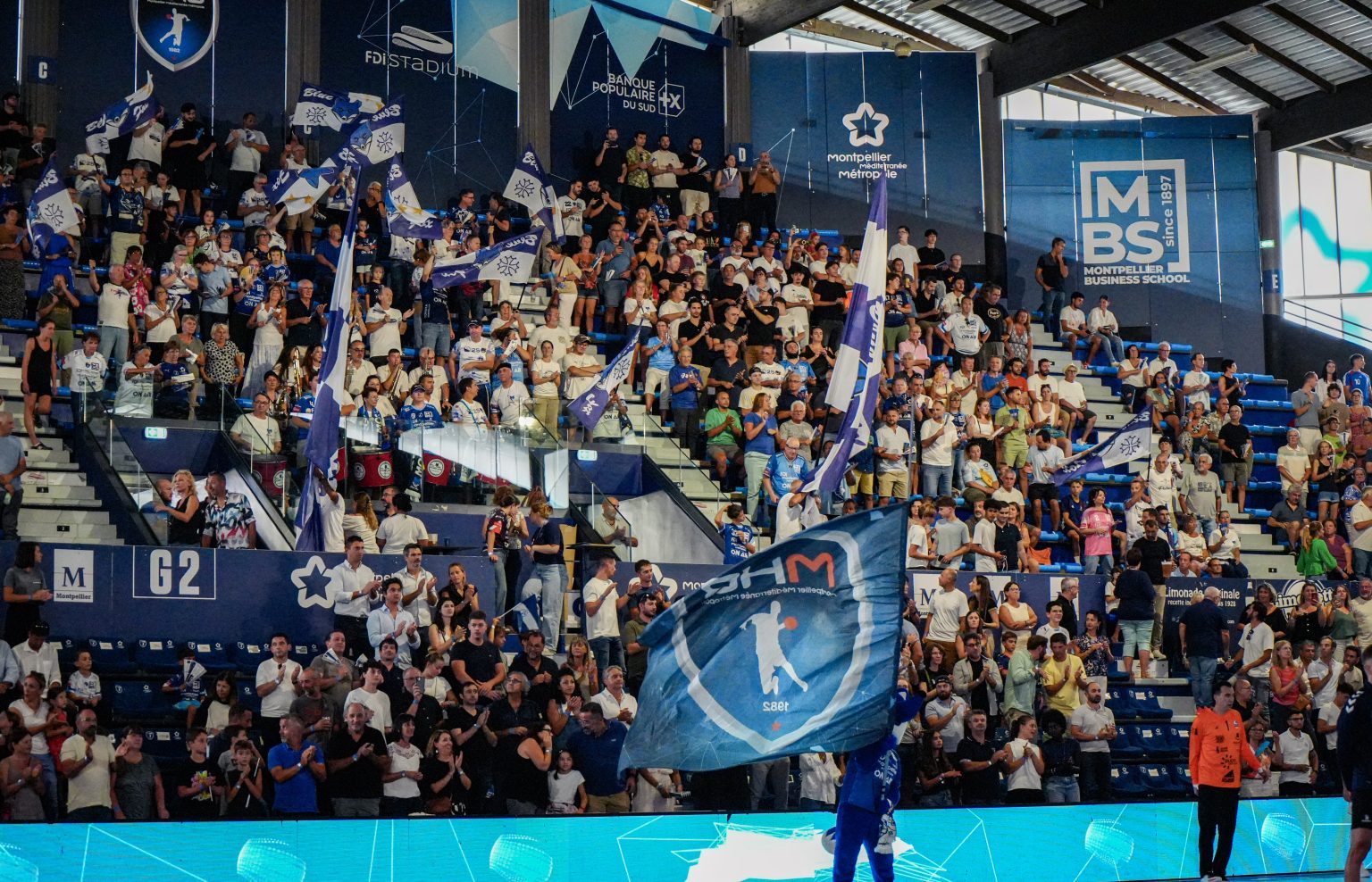 Supporters enthousiastes dans une arène sportive à Montpellier.