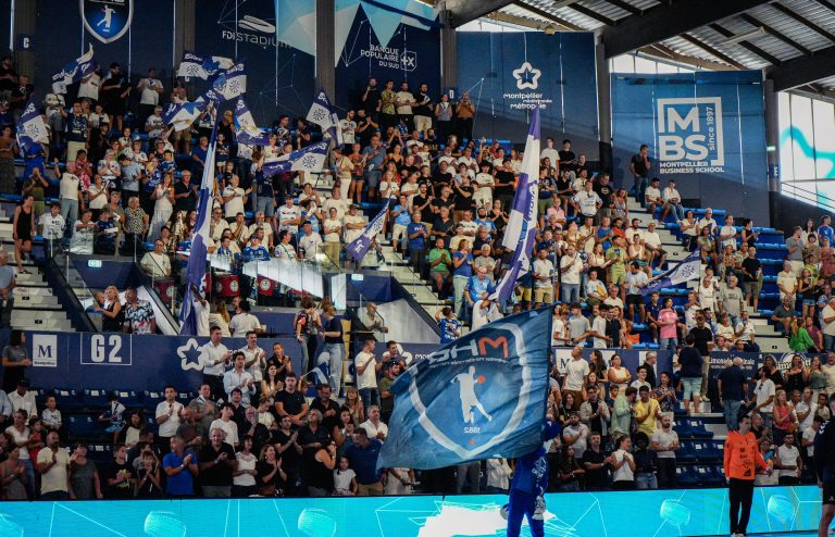 Supporters enthousiastes dans une arène sportive à Montpellier.