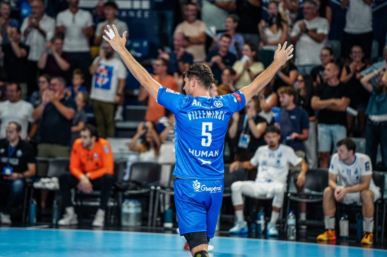 Joueur de handball célèbre célébrant sur le terrain.