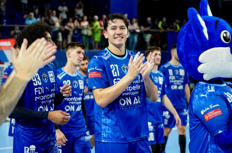 Joueurs de handball applaudissent avec mascotte.
