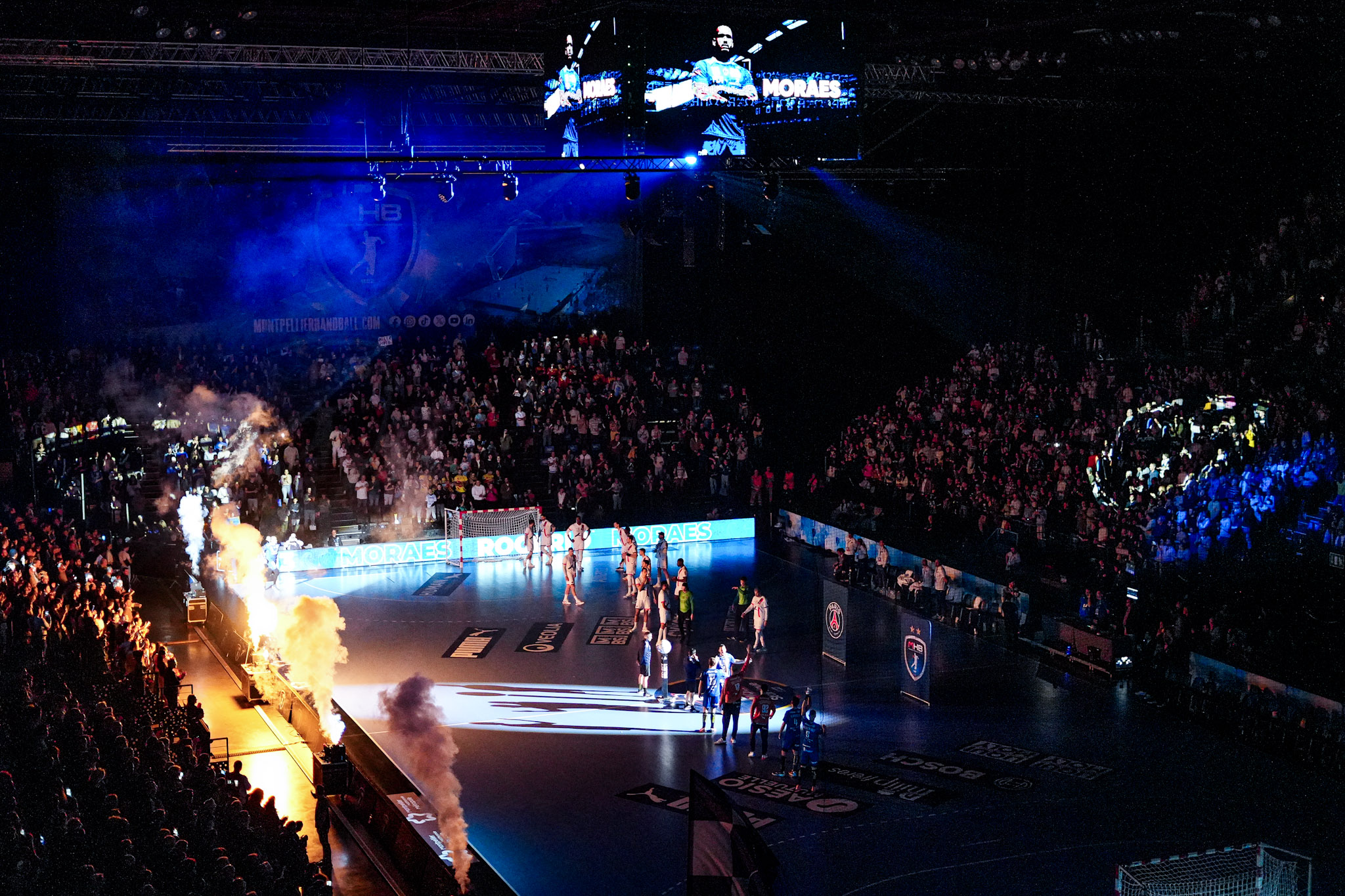Match de handball dans une salle comble.