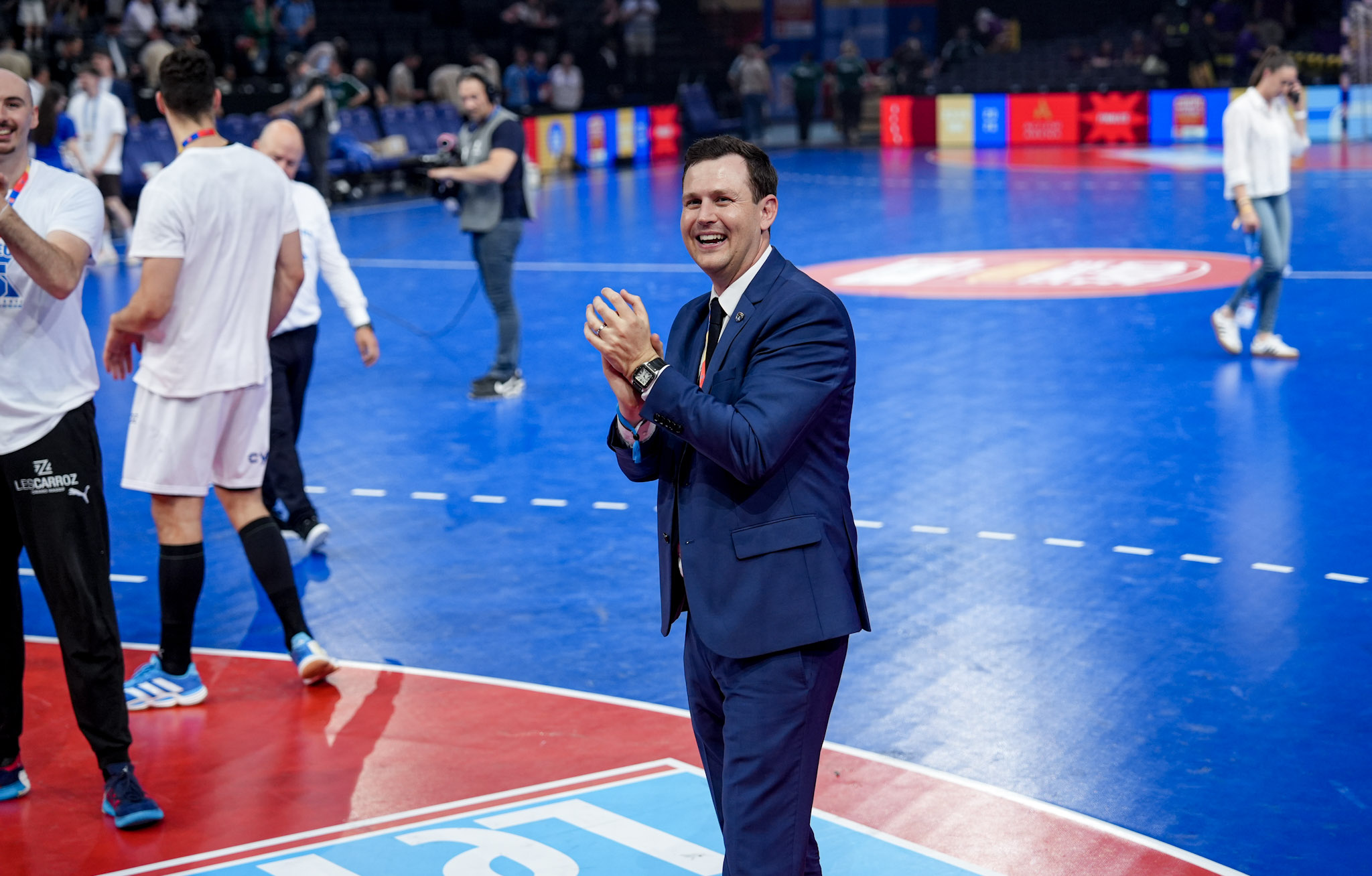 Homme applaudit sur terrain, événement sportif en salle.