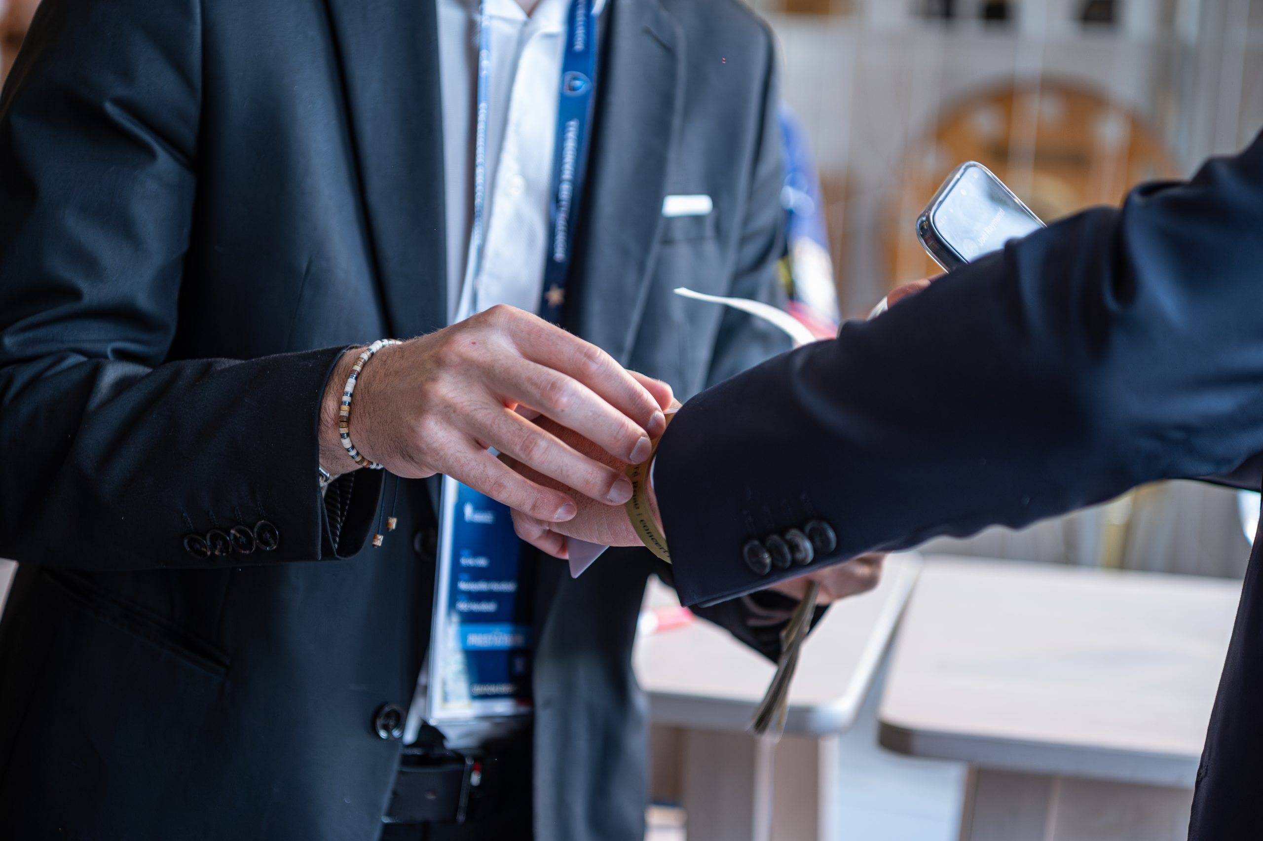 Homme scannant un bracelet à une conférence.
