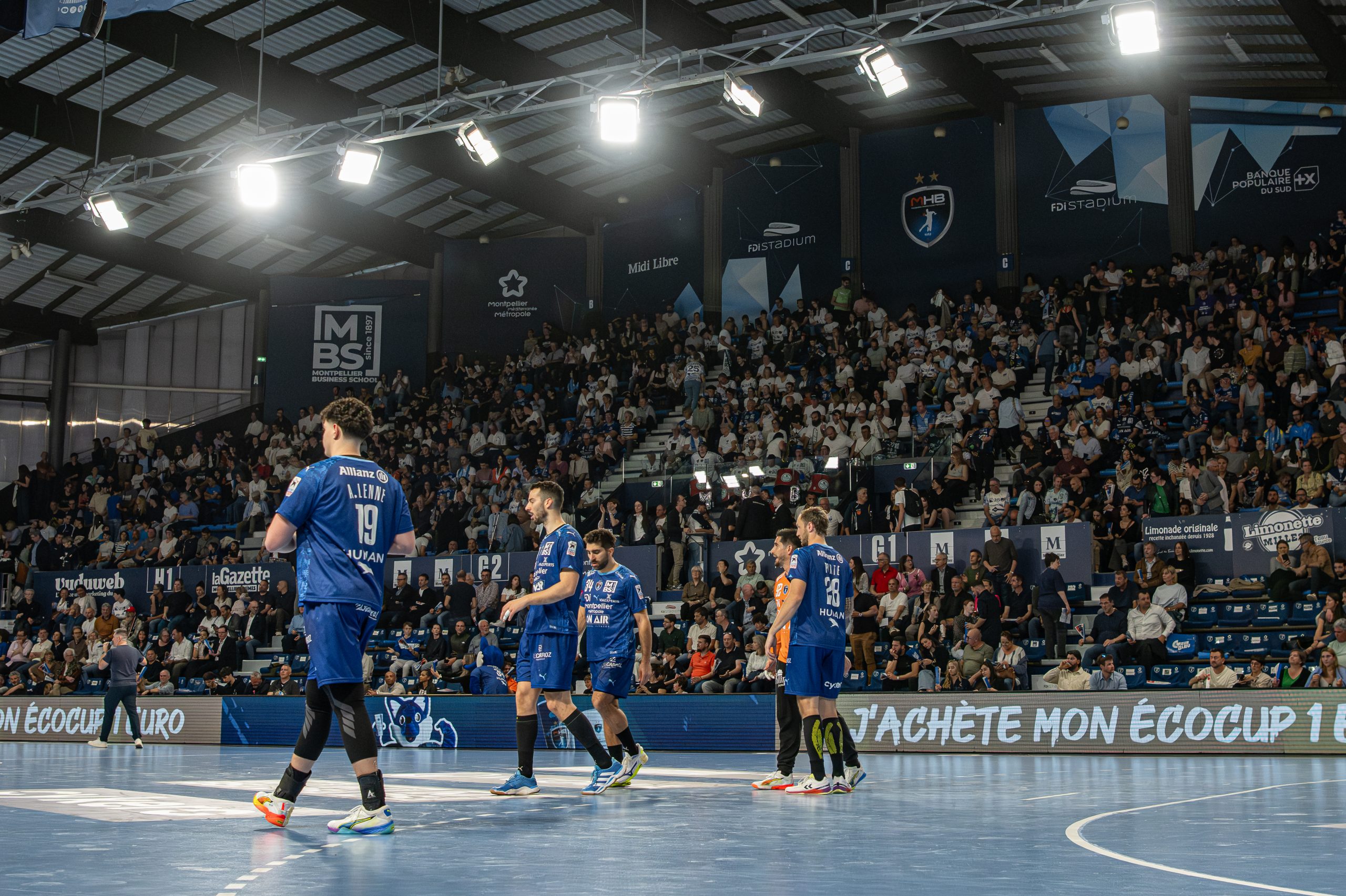 Match de handball avec public en tribunes.