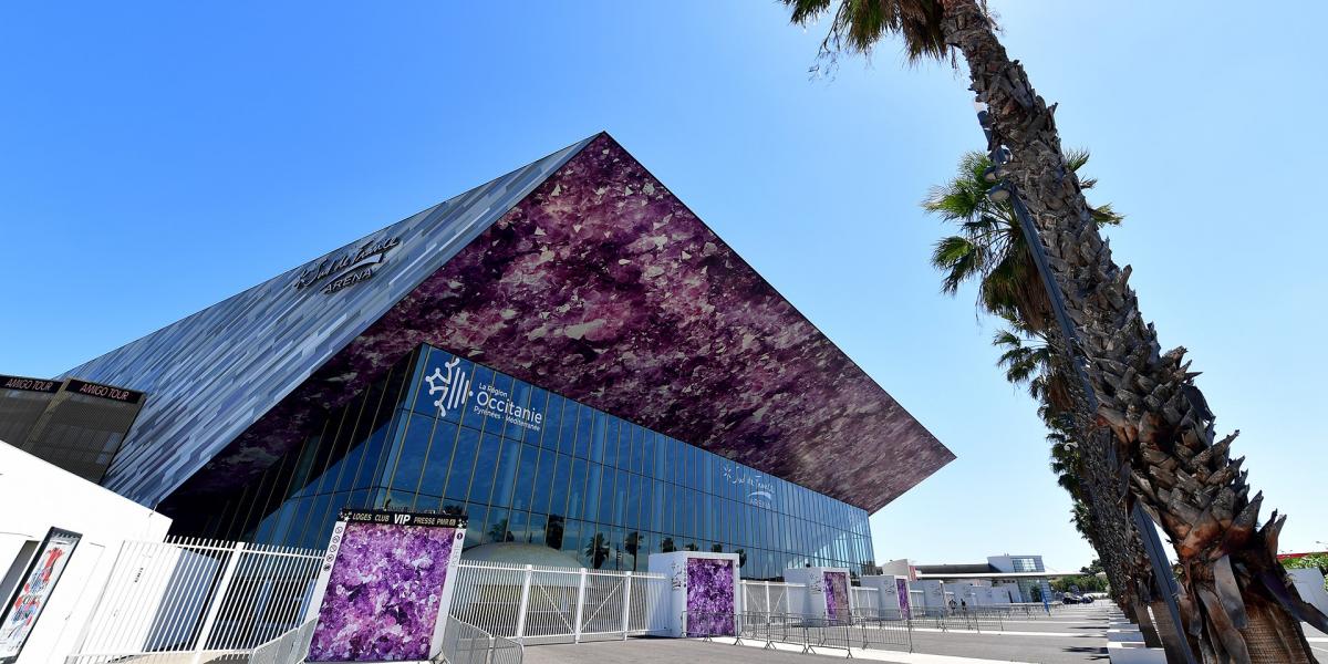 Arène moderne avec toit violet et palmiers.
